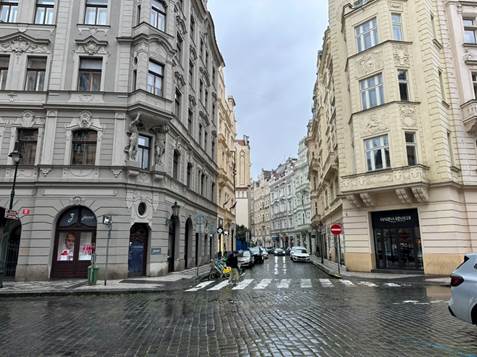 A street with buildings and cars on it

AI-generated content may be incorrect.